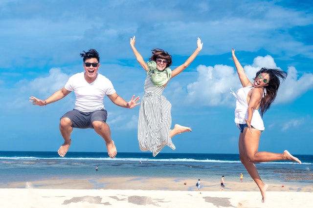 sautiller pour être en forme, photo de 3 personnes heureuses en train de sauter sur la plage